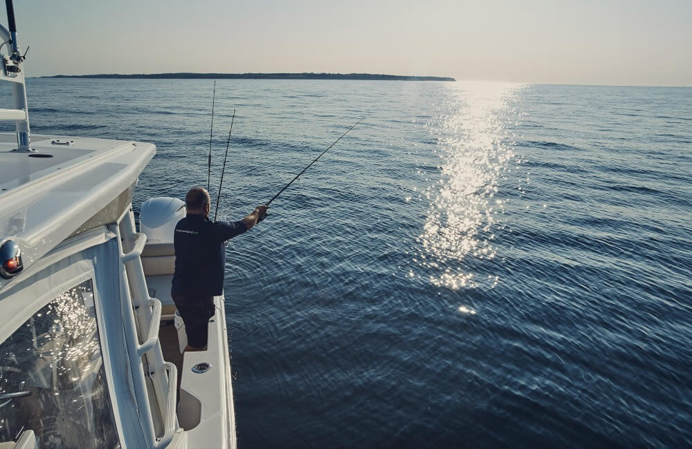 An angler fishes aboard a boat with Empire Fishing Charters